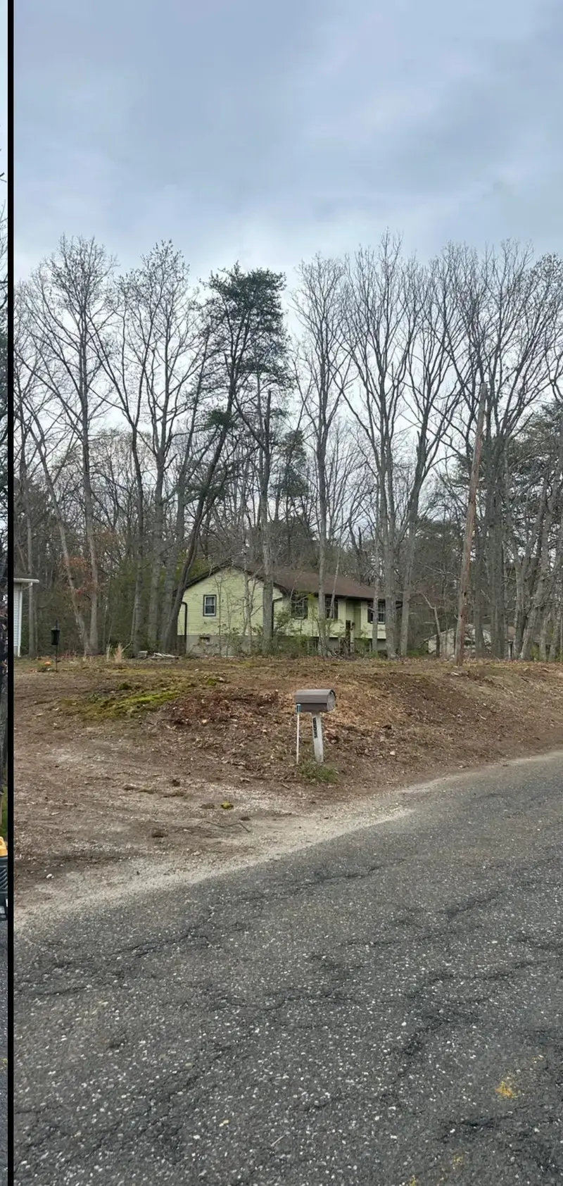 After: the same roadside lot cleared to bare ground, the mailbox standing alone and the house behind now in view.